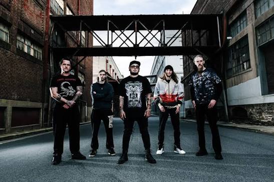 All five members of When Silence Breaks standing in an industrial laneway beneath a steel walkway.